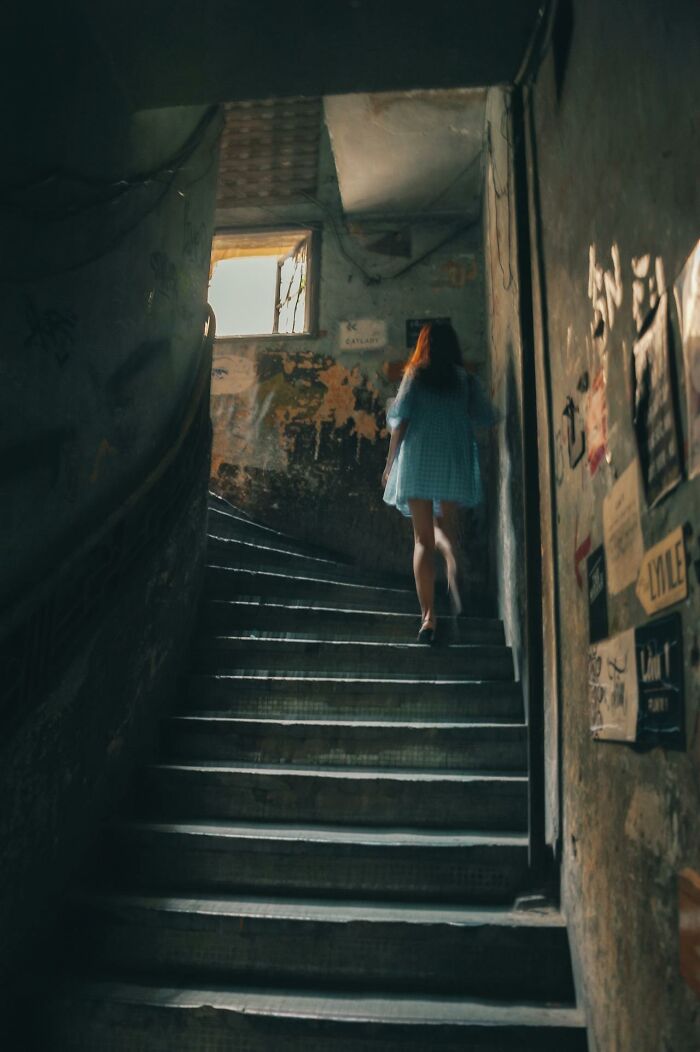 Mujer subiendo por escalera oscura, simbolizando el terror real.