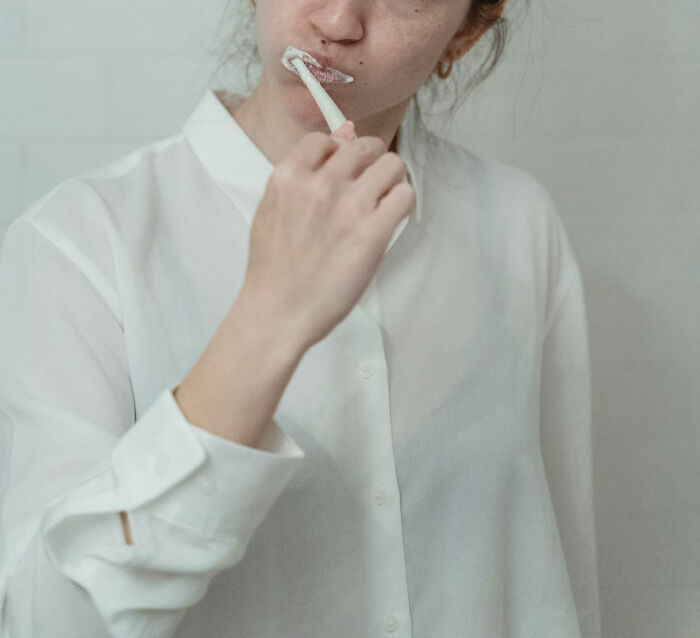 Person brushing teeth, highlighting oral hygiene, in context of weirdest things doctors removed from bodies.