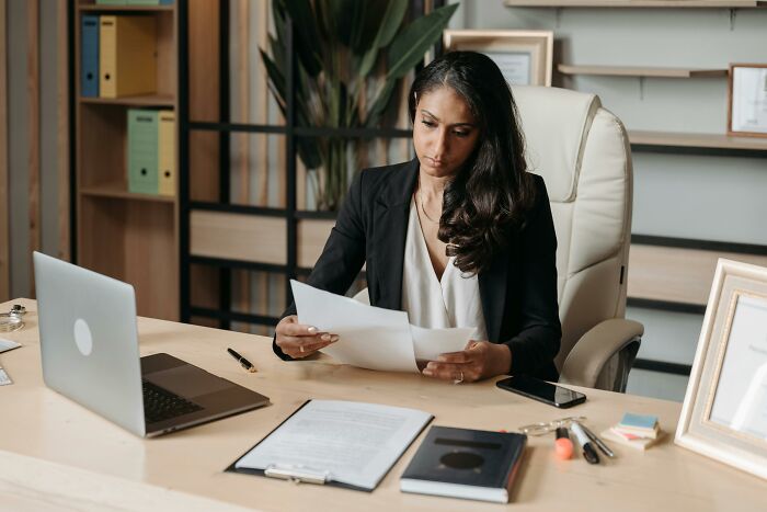 A woman in an office reviews documents, symbolizing life after graduating with a "useless" degree.