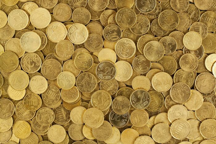 Assorted Euro coins scattered, representing historical facts and misconceptions about European currency and trade.