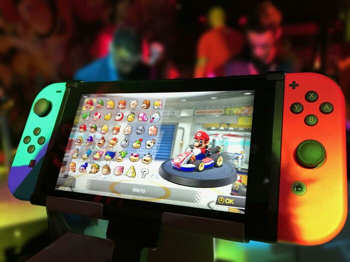 Nintendo Switch displaying Mario Kart character selection screen in a gaming room setting.