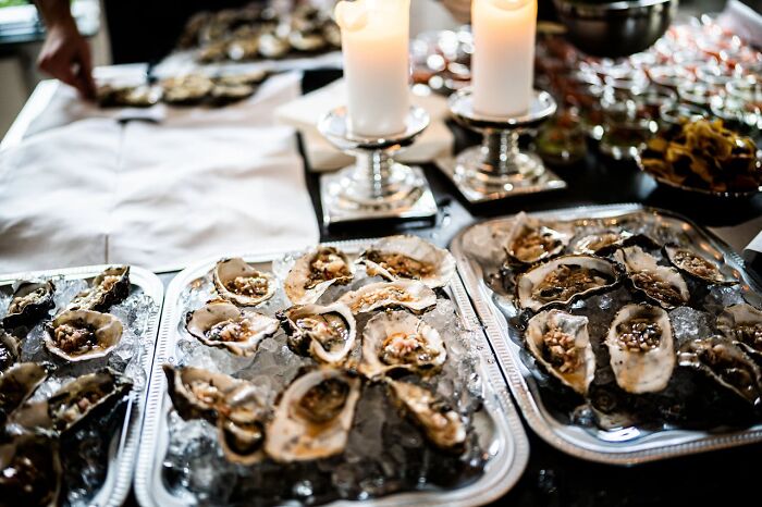 Wedding oysters on ice with candles, showcasing an extravagant display seemingly gone wrong.