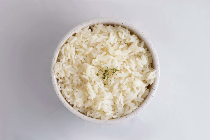 A bowl of cooked rice garnished with herbs, highlighting frugal kitchen choices.