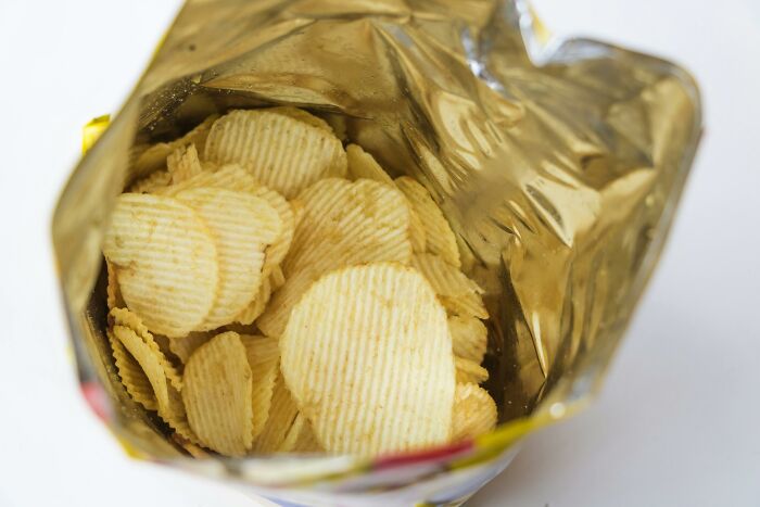 Bag of potato chips partially opened, illustrating modern snack packaging.