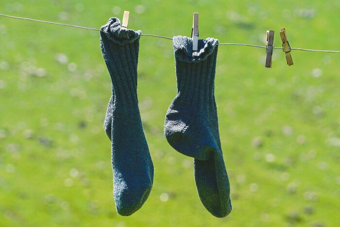 Green socks hanging on a clothesline, symbolizing unexpected cat gifts.