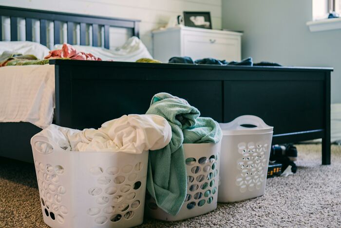 Laundry baskets filled with clothes in a bedroom, illustrating impactful home purchases under $500.