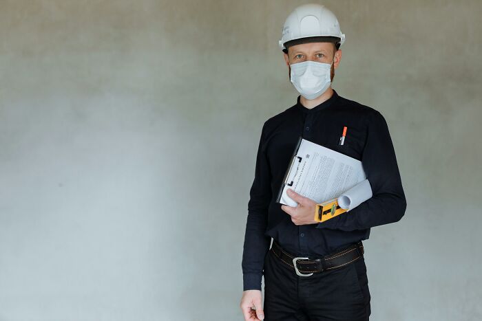 A person in construction gear holding documents, related to graduates with "useless" degrees adapting in their careers.