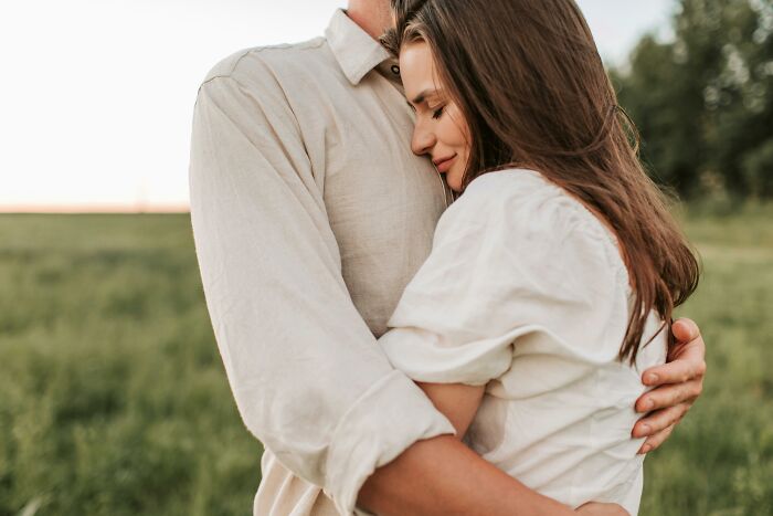 Couple embracing in a field, highlighting the experiences of bisexuals dating different genders.