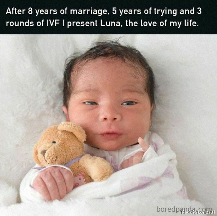 Newborn baby wrapped in a white blanket, holding a teddy bear, symbolizing positive and uplifting moments.