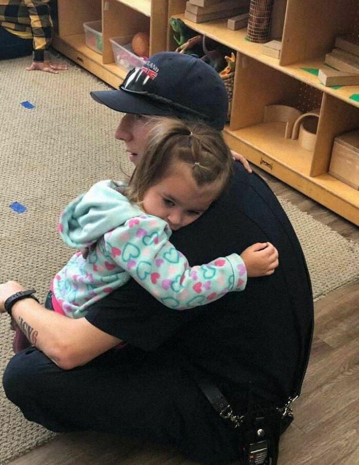 Child hugging a firefighter in a heartwarming moment, showcasing a positive and uplifting connection.