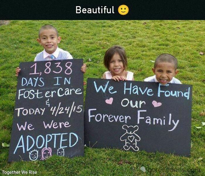 Children smiling with adoption signs, celebrating being adopted into a forever family.