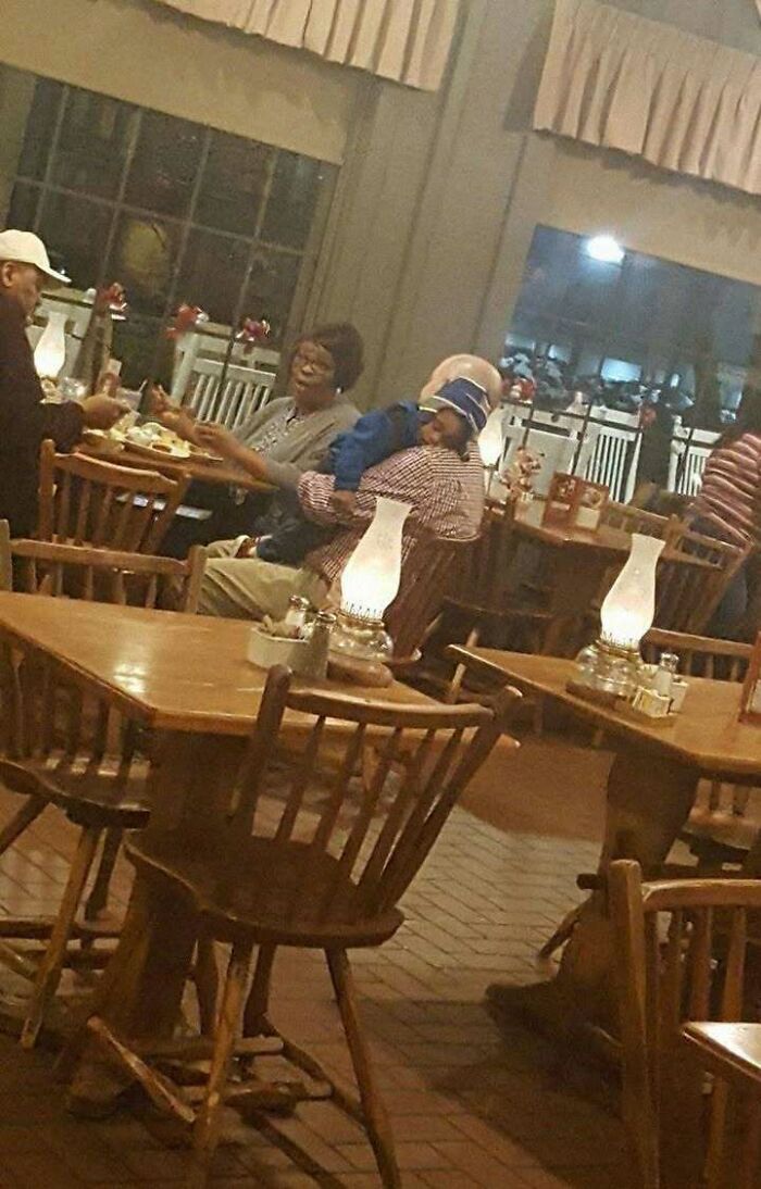 Family dining in a cozy restaurant, sharing a warm moment. Positive and uplifting atmosphere fills the room.