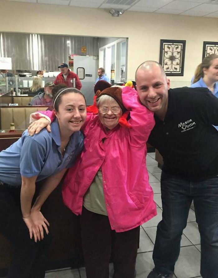 Three people smiling in a diner, radiating positive and uplifting vibes.