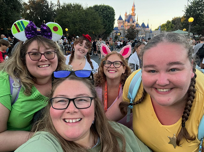 Group of plus-size park hoppers smiling at a theme park, embracing empowerment in colorful outfits. Group of plus-size park hoppers smiling at a theme park, embracing empowerment in colorful outfits.