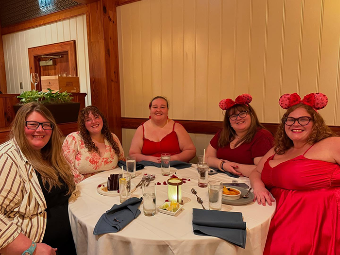 Plus size people smiling at a table, embracing empowerment and friendship, wearing red and enjoying a meal together. Plus size people smiling at a table, embracing empowerment and friendship, wearing red and enjoying a meal together.