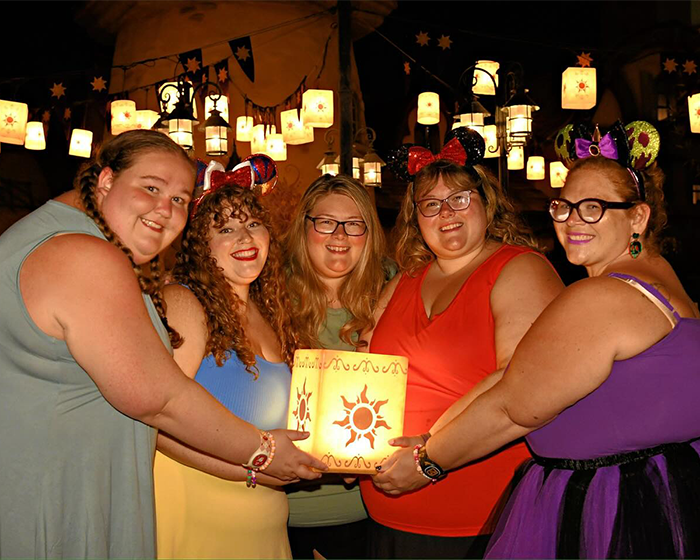 Plus-size park hoppers smile, holding a lantern, empowering plus-size people. Plus-size park hoppers smile, holding a lantern, empowering plus-size people.