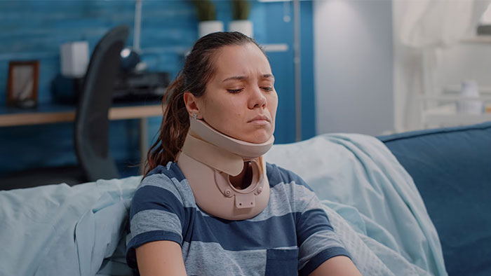 Person with a neck brace sitting on a couch, possibly related to social media mishaps.