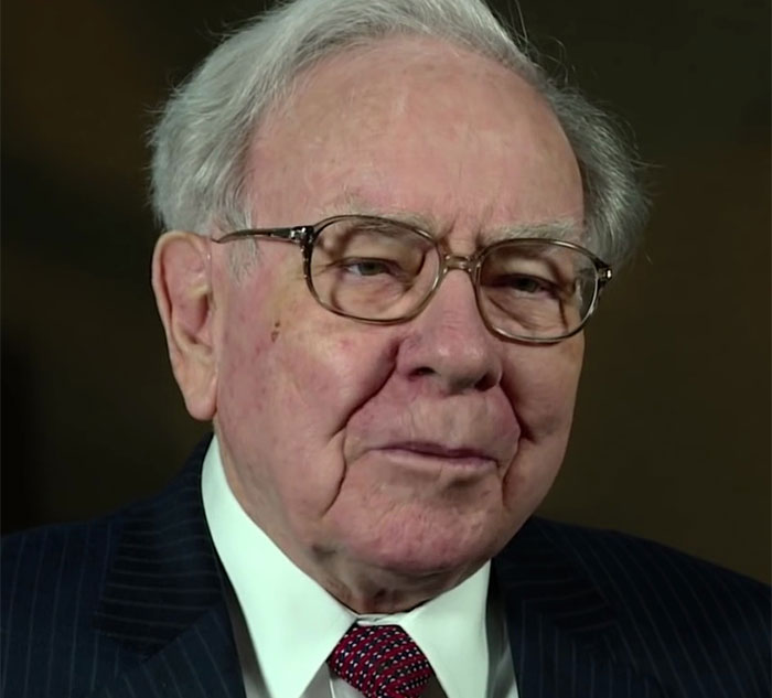 Elderly man in glasses and a striped suit, sharing fascinating facts in an interview setting.