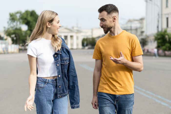 Man and woman talking outside, exemplifying how pretty privilege can favor both genders.