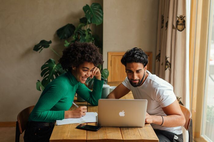 Two people at a table collaborating, highlighting the concept of pretty privilege in professional environments.