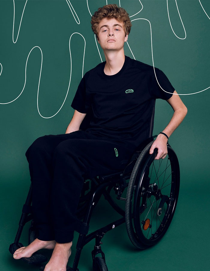 Young man in a wheelchair on a green background, wearing a black outfit, representing Prince Frederik. Young man in a wheelchair on a green background, wearing a black outfit, representing Prince Frederik.