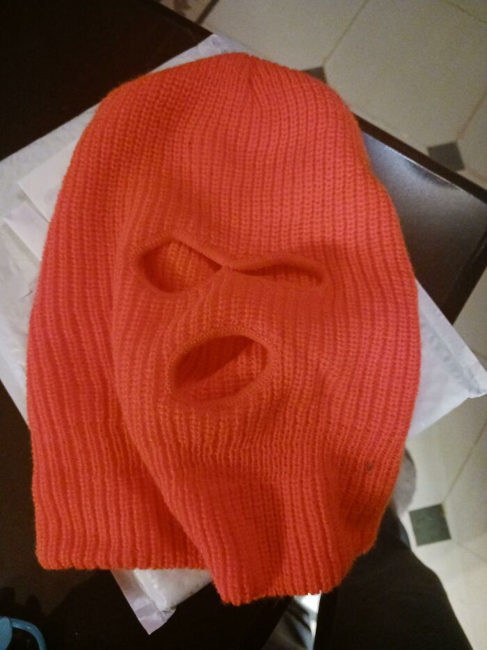 Orange ski mask repurposed for unique uses, showcasing product versatility.