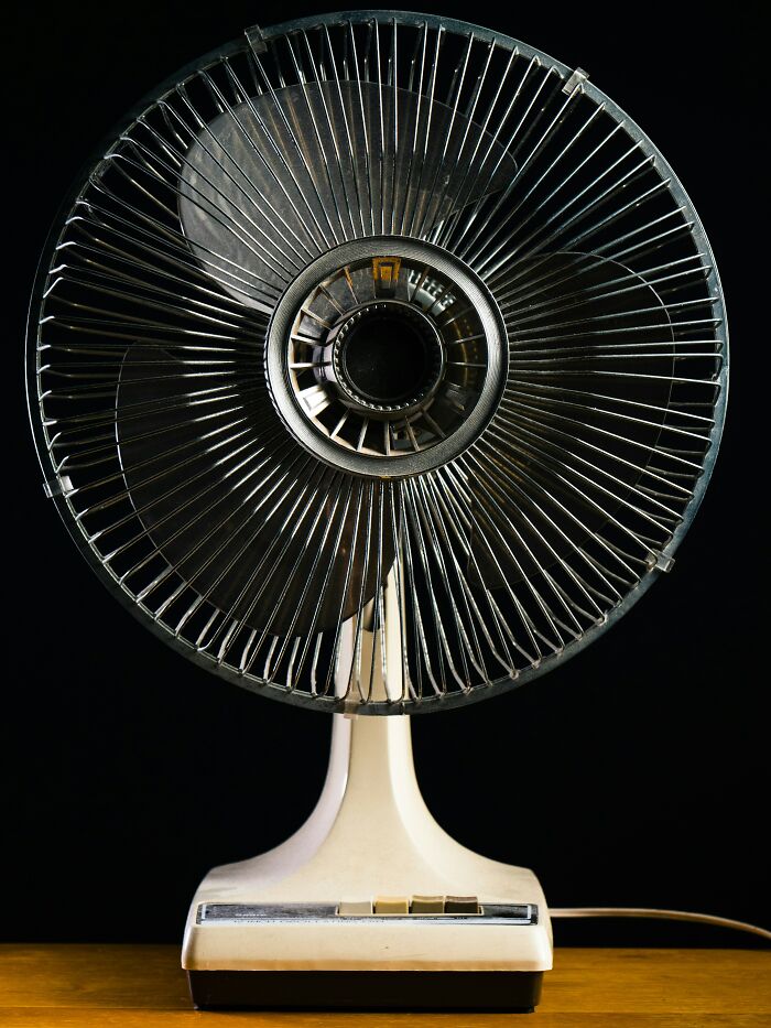 Vintage electric fan repurposed for unique use in a dimly lit setting, showcasing creative product applications.
