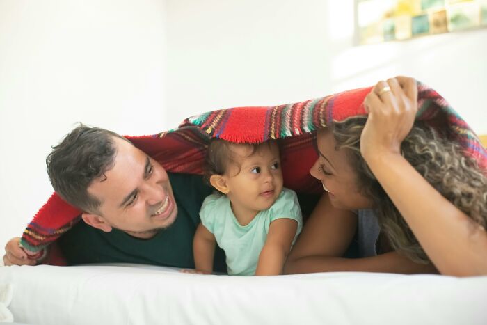 Family smiling under a red blanket, highlighting grandchildren bonding moments.