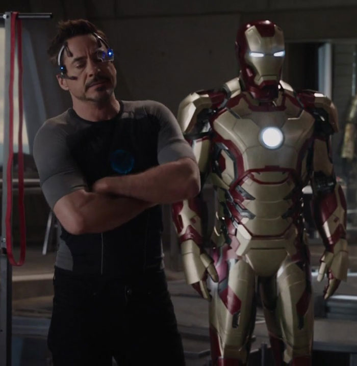 Iron Man suit displayed in a high-tech workshop setting from Iron Man 3 movie.