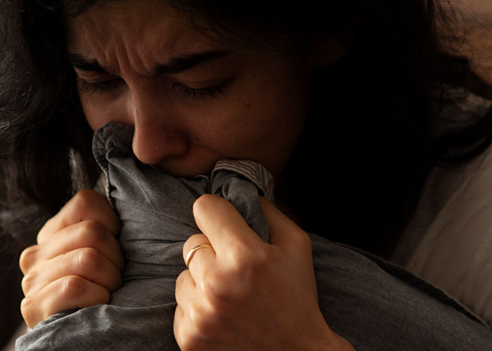 Person holding a pillow, appearing upset, highlighting friendship and care themes.