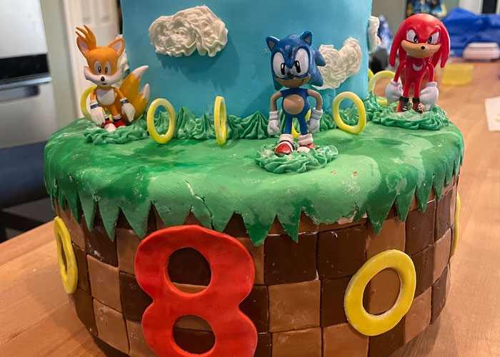 Sonic-themed cake with figurines of Sonic, Tails, and Knuckles, showcasing friendship in cake design.