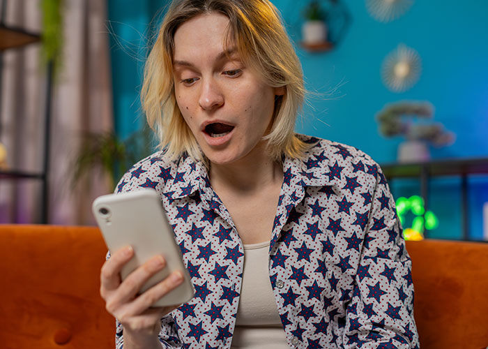 Person in a star-patterned shirt looks surprised while reading a message, highlighting issues with uncaring friends.