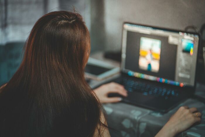 Person editing a photo on a laptop, illustrating common job misconceptions.