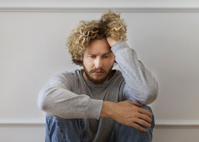 Man appearing stressed, in casual clothing, representing family ATM financial pressure. Man appearing stressed, in casual clothing, representing family ATM financial pressure.
