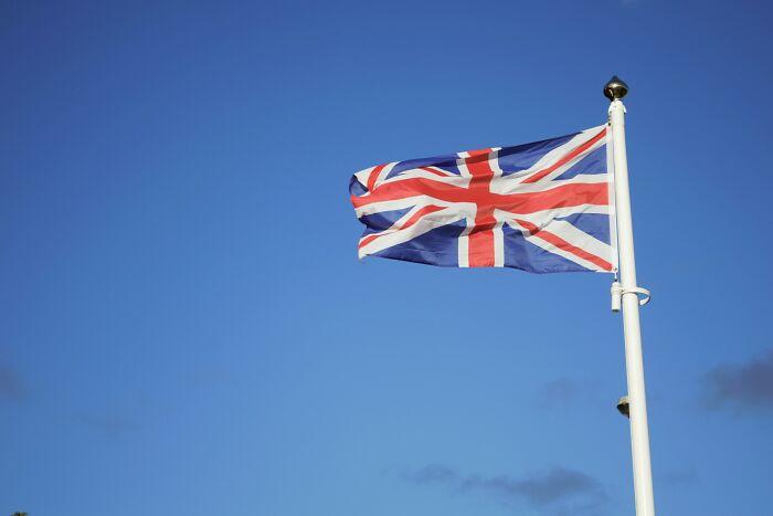 Union Jack flag waving against a clear blue sky, representing European news stories.
