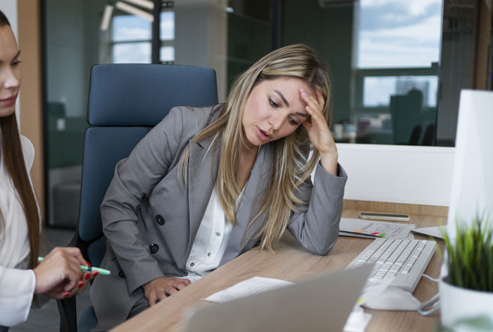 Woman in office looking concerned, discussing a coworker's actions in a walking competition report. Woman in office looking concerned, discussing a coworker's actions in a walking competition report.