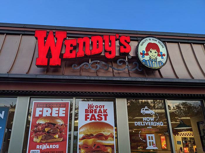 Wendy's restaurant exterior with promotional posters in the window.