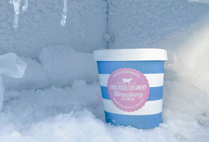 Lewis Road Creamery strawberry ice cream in a frosty freezer setting.