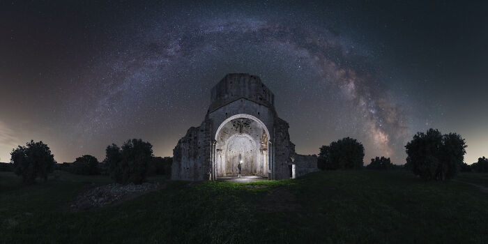 Ancient stone archway under a stunning starry sky, showcasing natural landscapes and cosmic beauty.
