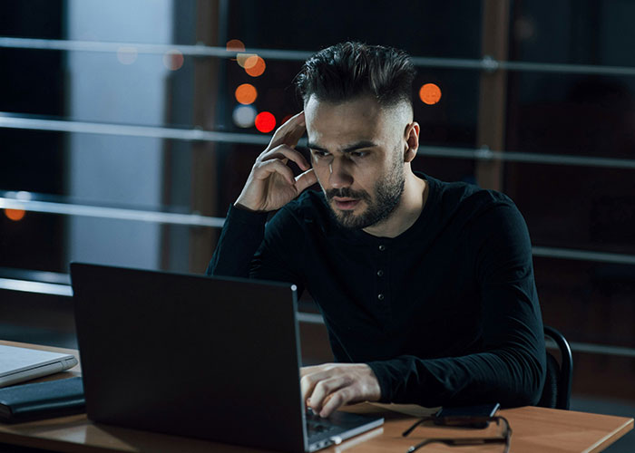 Man at a laptop, appearing focused and concerned, representing a scary "need to leave" experience.