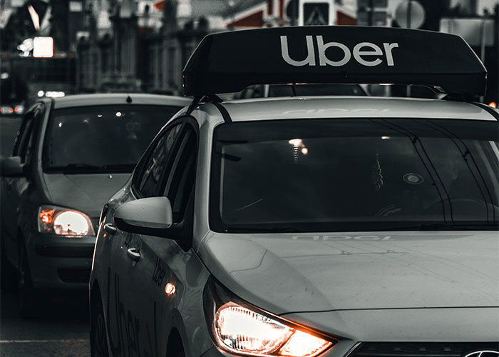 Uber car at night, headlights on, conveying an urgent sense of needing to leave quickly.