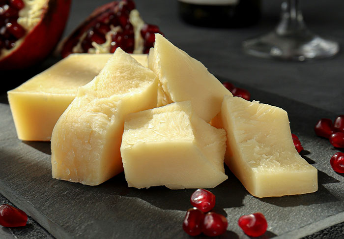 Cheese cubes on a slate board with pomegranate seeds, capturing disturbing facts about food pairings.