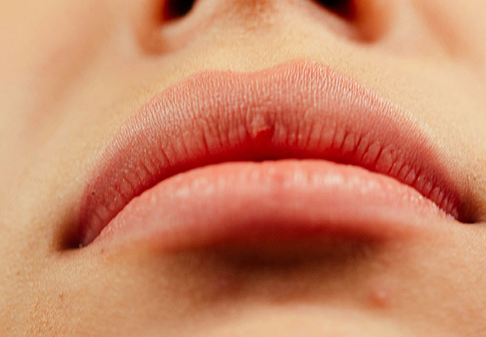 Close-up of a person's lips and nose, highlighting texture, referencing disturbing facts.
