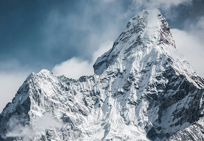 Snow-covered mountain peak under a clear sky, capturing a breathtaking yet potentially disturbing natural view.