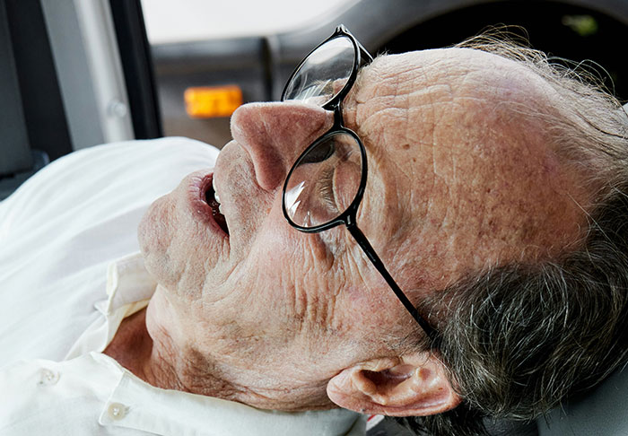 Elderly man with glasses in a reclined position, embodying the unsettling truth of disturbing facts.