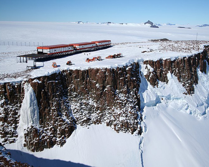 Antarctica research station atop a snowy cliff, highlighting remote isolation.