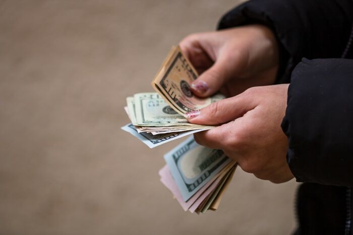 Hands counting money, relating to reasons for not speaking to former best friends anymore.