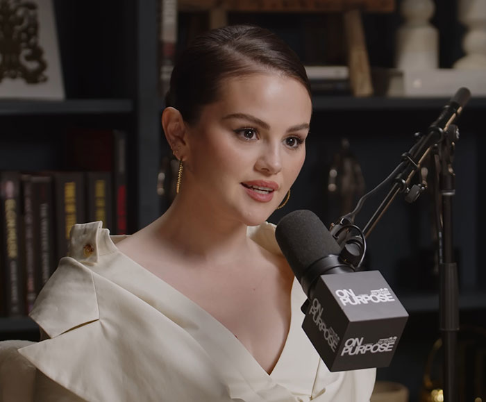 Selena Gomez in a podcast studio, microphone labeled "On Purpose," discussing her fianc&eacute; Benny&rsquo;s views on treating women.