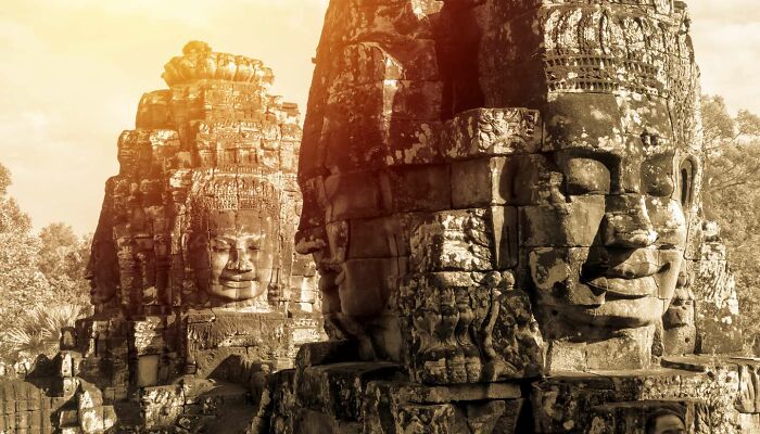 Ancient stone faces of a forgotten place, illuminated by sunlight, evoking mystery and history.