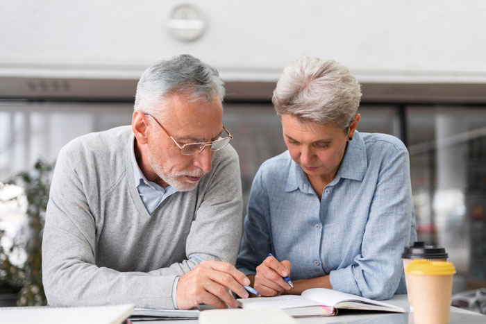 Older couple reviewing documents, highlighting family and inheritance discussions without children.
